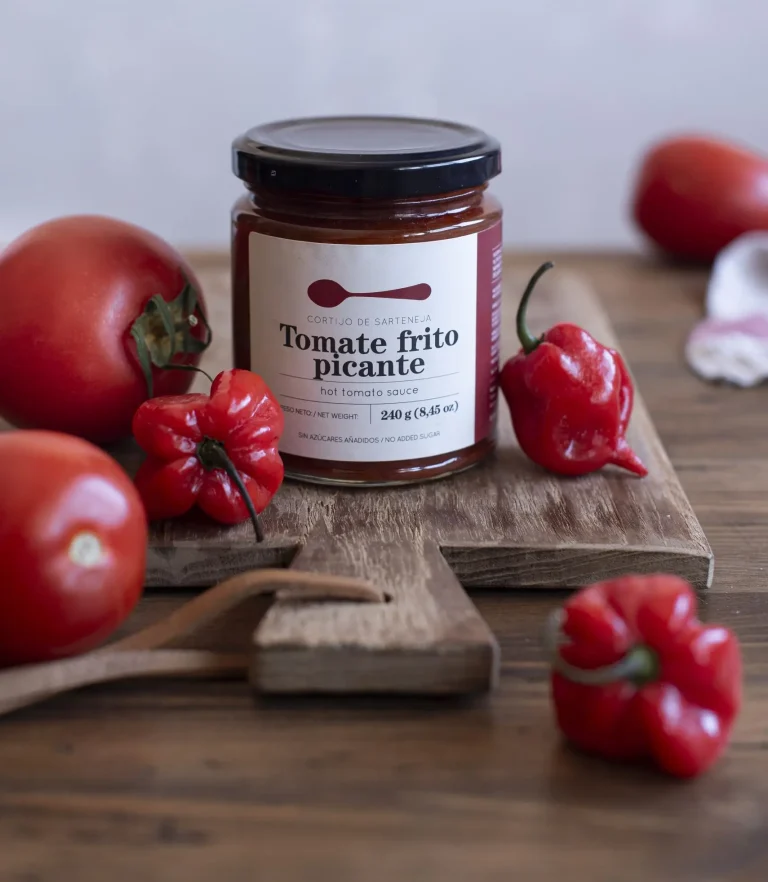 salsa de tomate frito casero picante con tabla de madera y tomates naturales